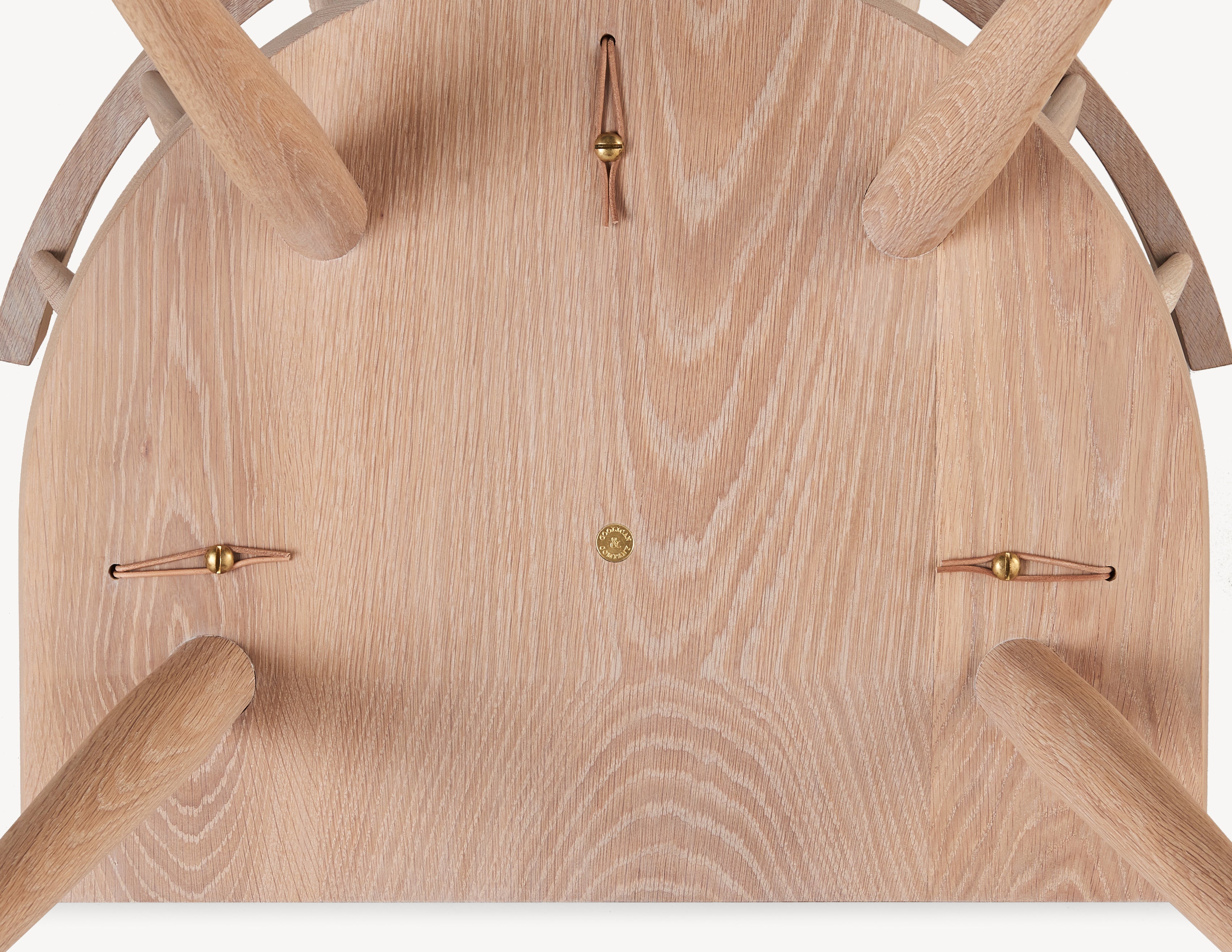 bottom view of wooden windsor lounge chair with leather and brass details.