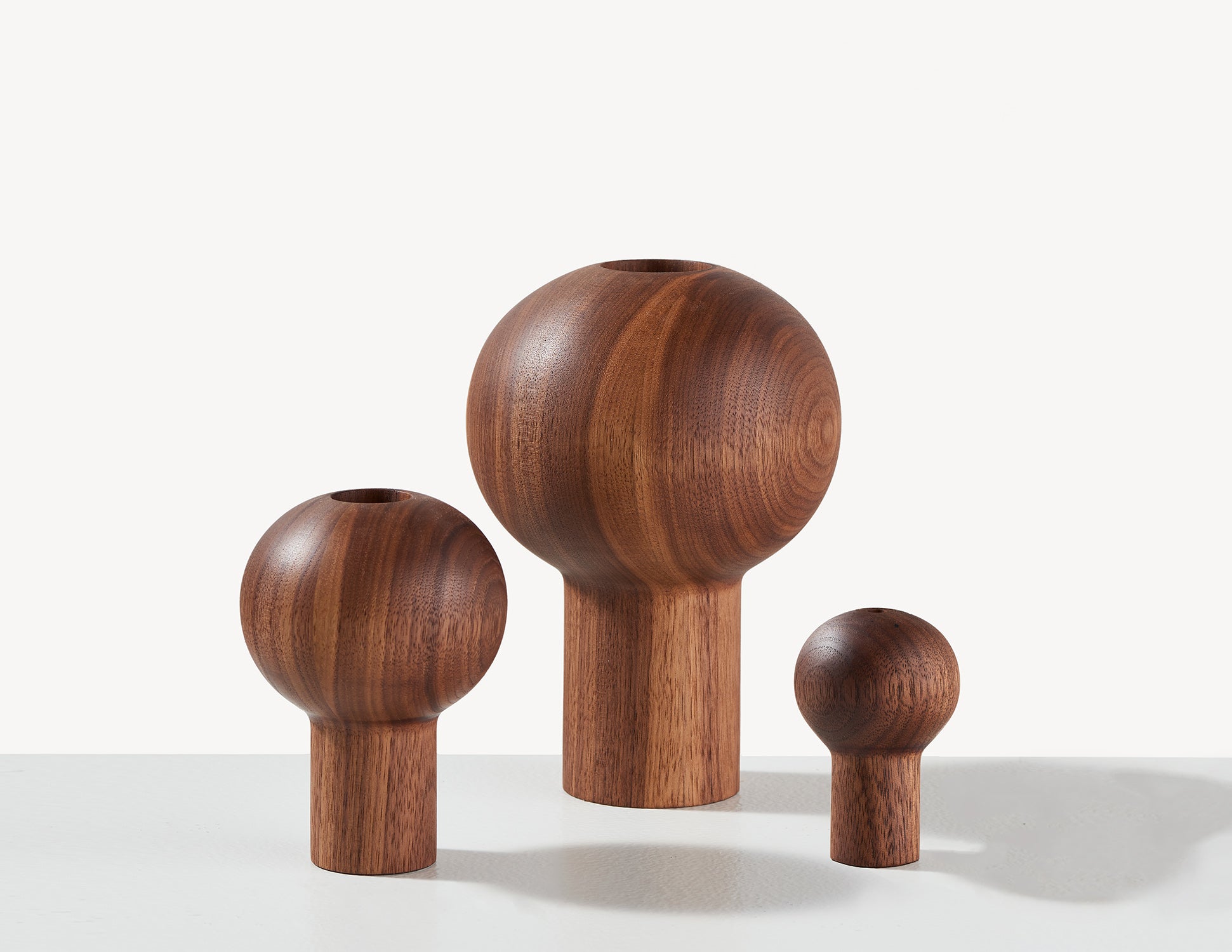 three different-sized wooden dry vases in walnut wood.